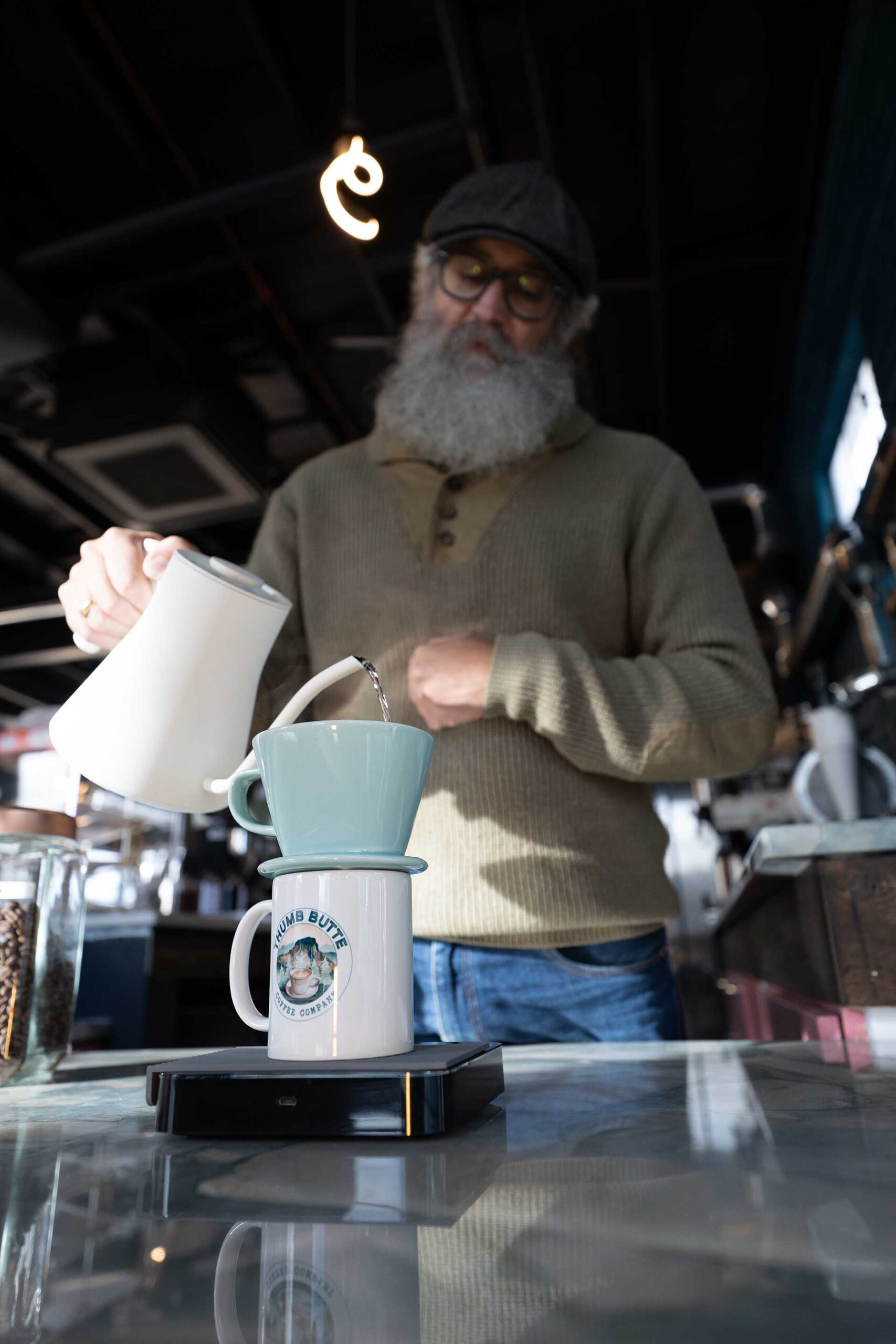 Coffee pour from kettle by barista in Prescott AZ Front entrance of John Hancock Barber shop inside Founding Fathers Collective in Prescott