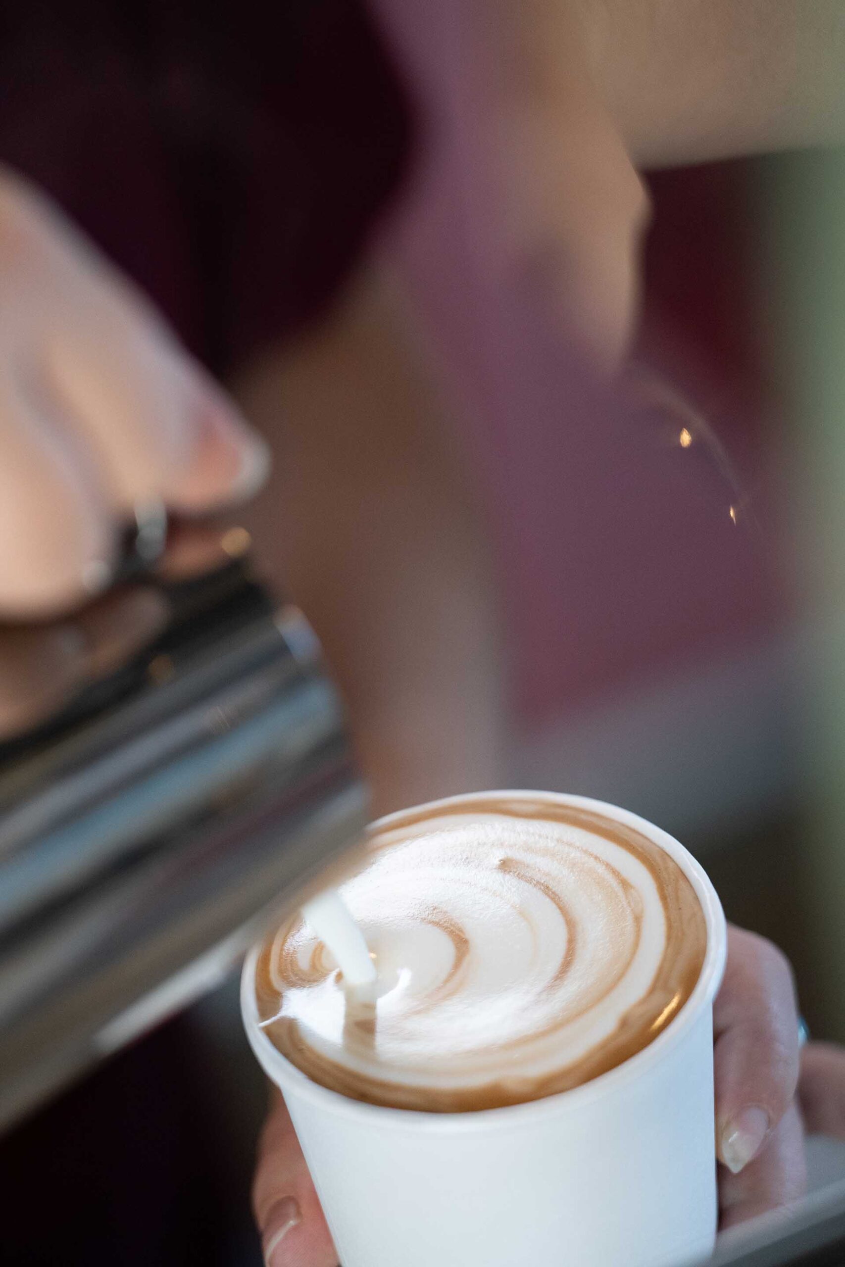 Skilled barista crafting latte in Prescott AZ Self-serve tap wall at City Tavern with digital beer menus and wooden-handled taps