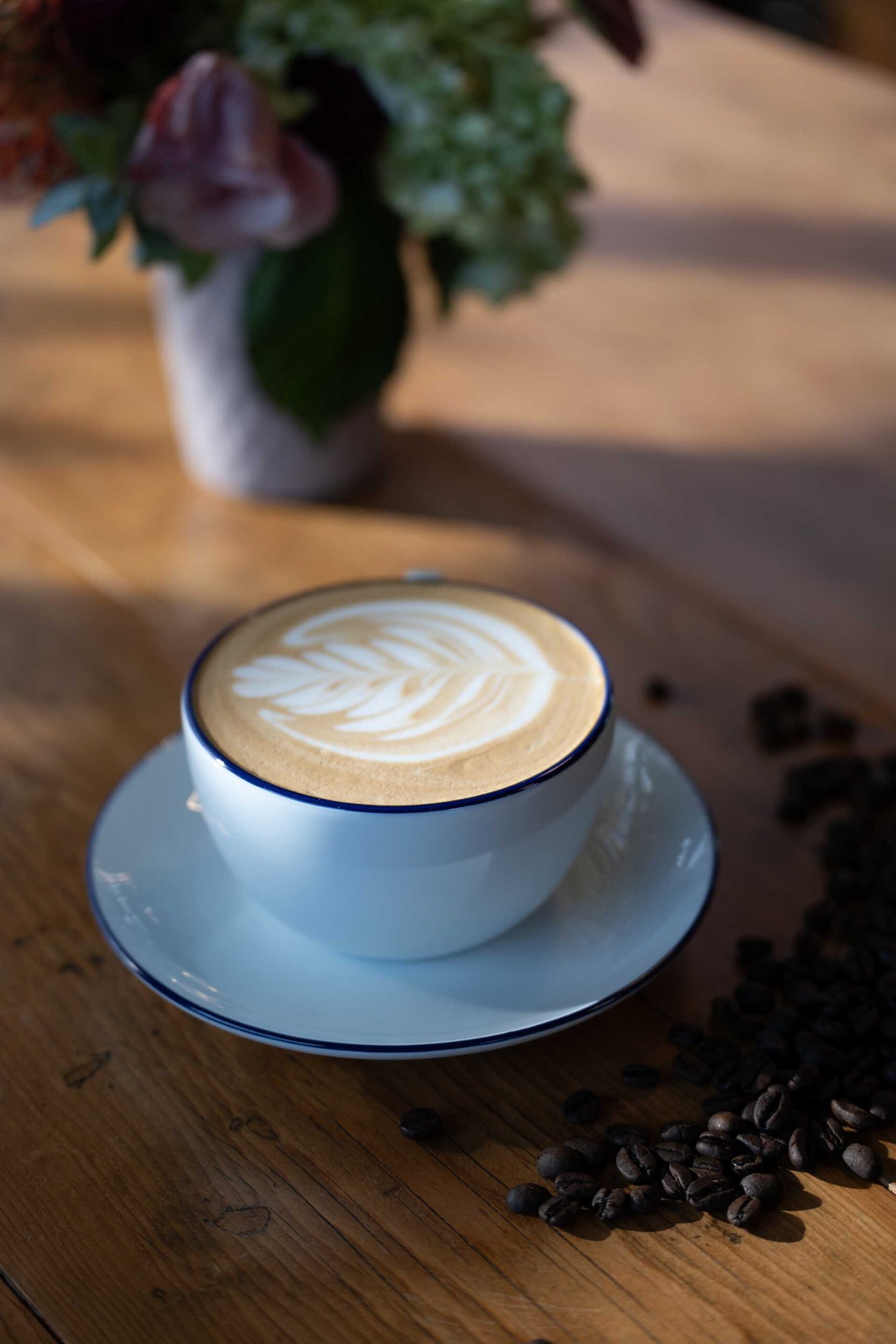 Smooth latte presented at local Prescott AZ coffee shop Latte art cup with beans beside at Prescott AZ café